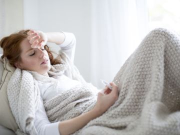 Kranke Frau mit Fieberthermometer